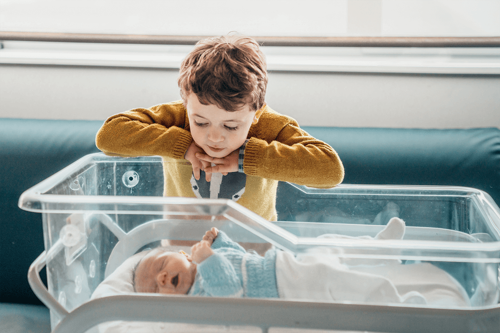 Kid looking at a baby